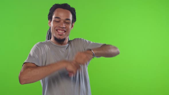 Young African American Man Student Performs Simple Dance Stands on Green Studio