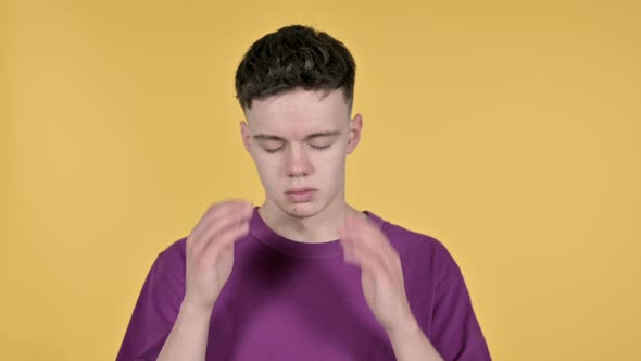 Young Man with Headache on Yellow Background