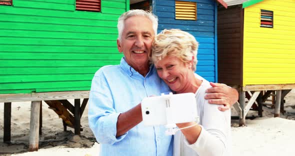 Senior couple taking a selfie on the beach