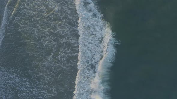 Aerial shots of breaking waves on a hazy summer morning in Malibu, California