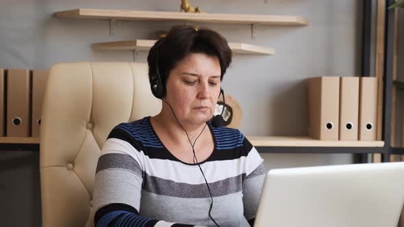 Old Woman Wearing Headset, Holding Video Call Support Services with Customer