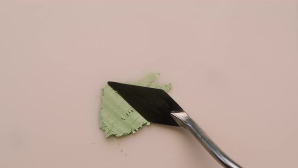 Smearing Green Cream on Beige Background Sample Foundation Texture Closeup
