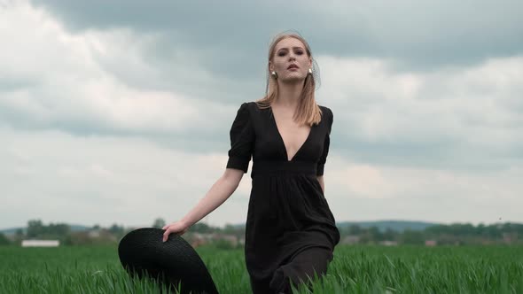 Flamboyant Girl In Black Dress Goes By The Field.