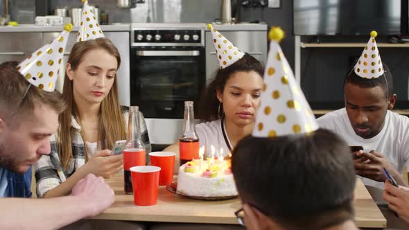Young people checking smartphones on birthday party
