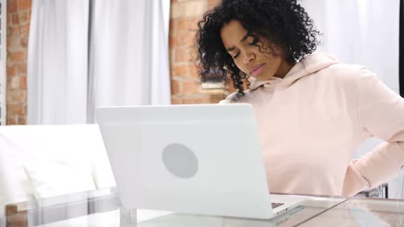 AfroAmerican Woman with Back Pain Trying to Relax on Couch at Home