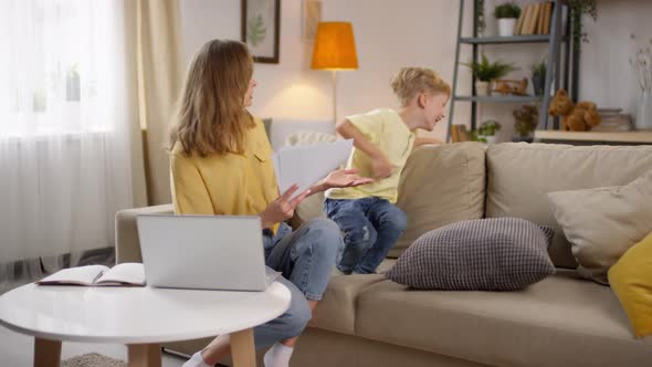 Playful Children Bothering Mother Working from Home