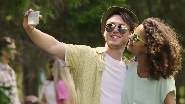 Cheerful Man and Woman Smiling and Pouting to Smartphone Camera for Selfie