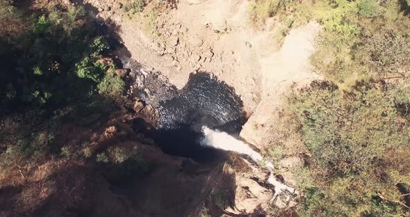 Drone footage rotating and closing up from top of big waterfall