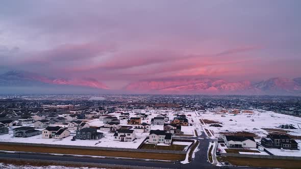 Utah Valley in winter during colorful sunset with houses in snow