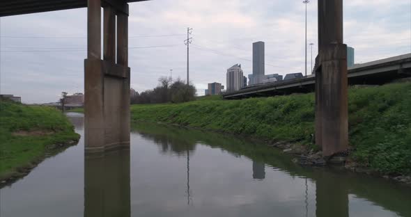 This video is about an aerial view of the Buffalo Bayou near downtown Houston on a cloudy day. This