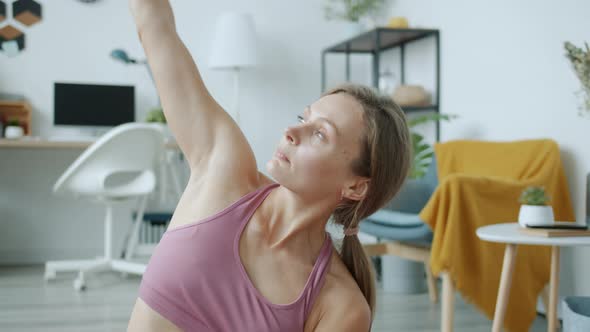 Slow Motion of Active Person Doing Yoga Stretching Arms Indoors in Apartment