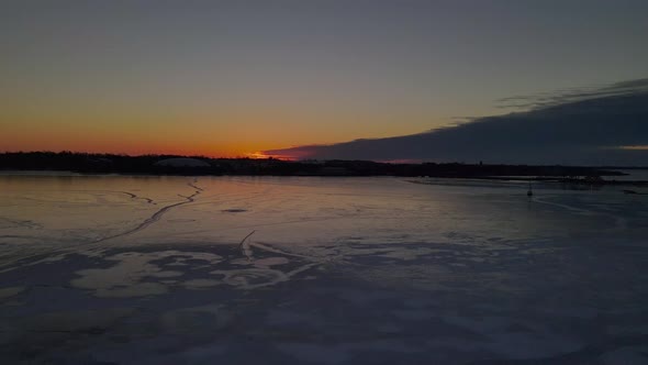 aerial  over a frozen lake during sunrise