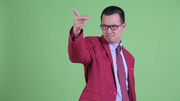 Happy Asian Businessman with Eyeglasses Pointing Finger and Directing