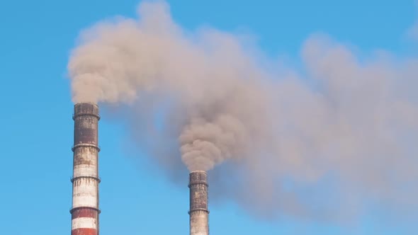 Closeup of Thermal Power Plant High Pipes with Black Smoke Moving Upwards Polluting Atmosphere