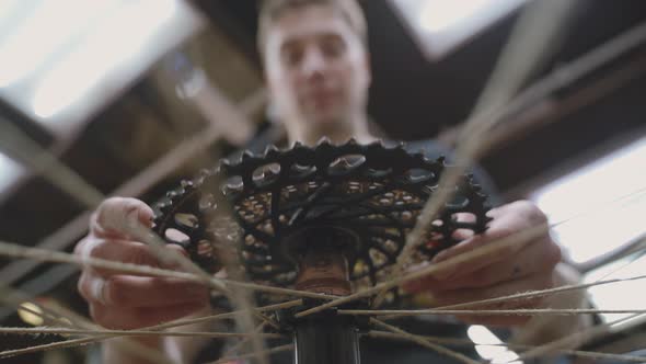 Mechanic Repairing Bicycle Wheel in Workshop