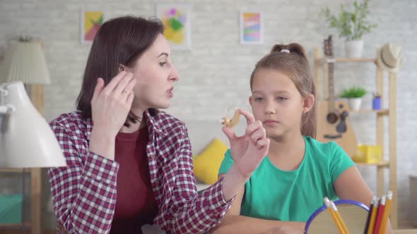 Young Woman Tells a Teenage Girl About a Hearing Aid