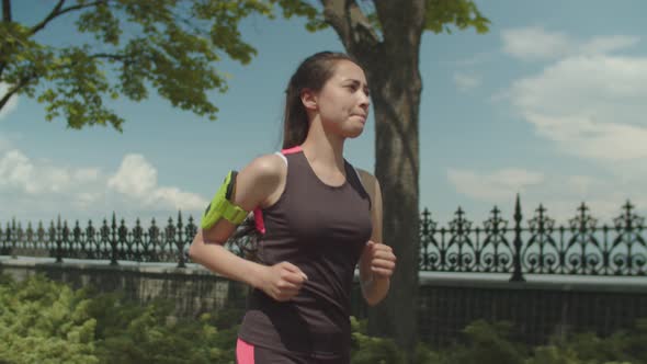 Female Athlete Jogging in City Park During Workout