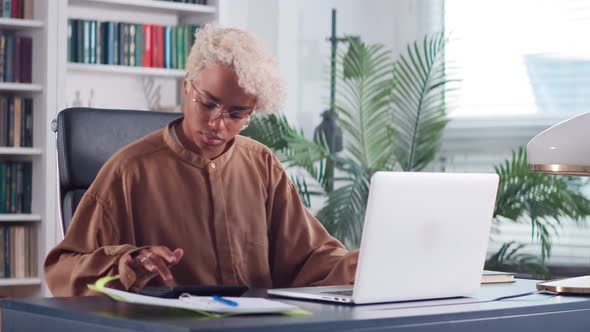 Overjoyed African American Business Woman with Calculator in Office