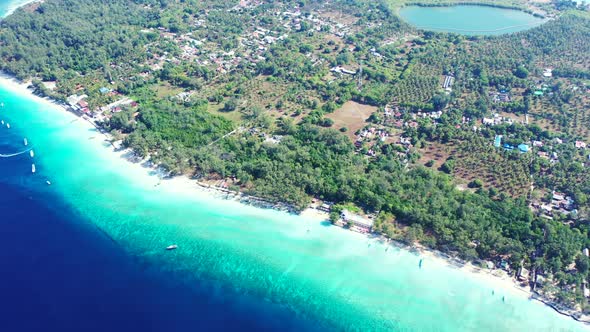 Deep blue sea next to turquoise shallow lagoon around tropical island in Gili meno, Indonesia with w