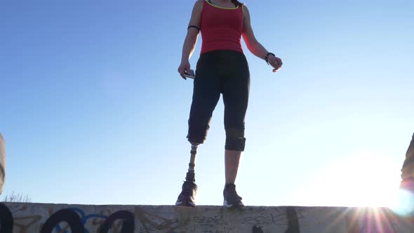 Slow motion shot of woman with leg prosthesis jumping from a wall