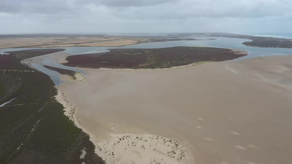 Aerial footage of a white sandy beach at the mouth of the River Murray in Australia