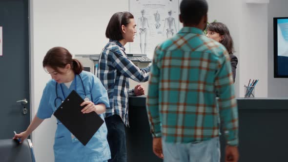 Busy Receptionist Giving Assistance to Diverse Group of Patients