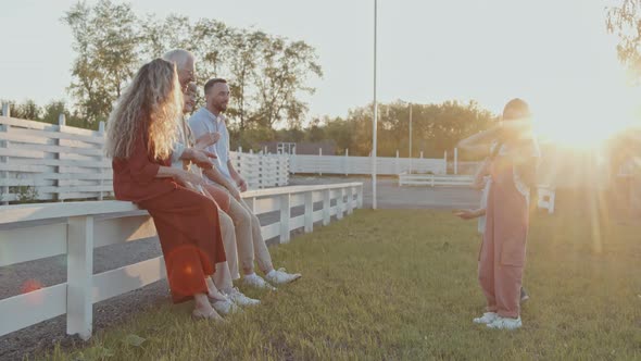 Family Watching Children Dancing Outdoors