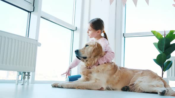 Little Girl Sitting with Golden Retriever Dog