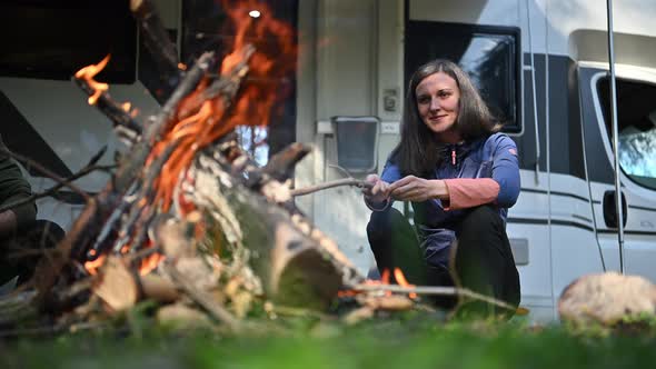 Woman Hanging Out Near Campfire and Camping in His Camper Van