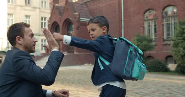 Young Father in Suit and Teen Boy Doing Goodbye Ritual Before Going To School, Child in Uniform