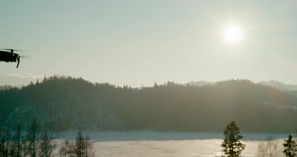 UAV Drone Flying From Left to Right Over Mountains at Sunset