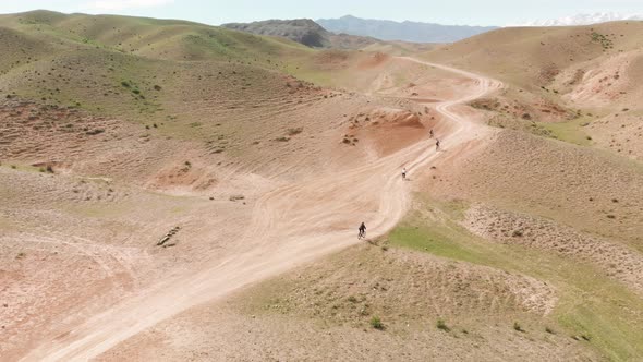 Drone Shot Group of Bicyclist Ride in the Mountains of Kazakhstan