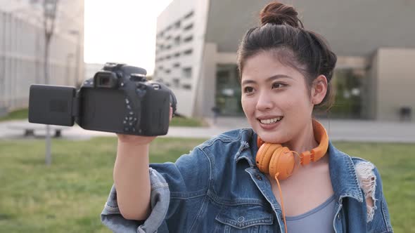 Asian woman vlogging and using camera, social media influencer content creator lifestyle
