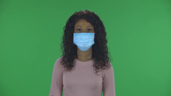 Portrait of Beautiful African American Young Woman in Medical Mask Is Looking Straight. Burning