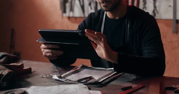 A Blacksmith Uses a Tablet to Create a Sketch of a Future Product