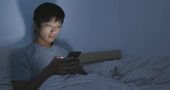 Man Use of Cellphone on Bed