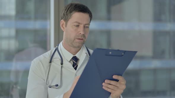 Serious Doctor Studying Medical Documents, Paperwork