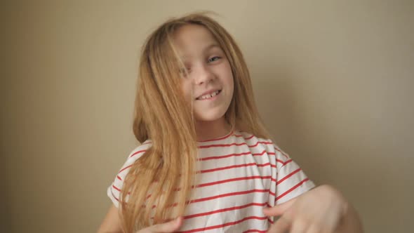 Happy Small Blonde Girl Looking Into Camera Clapping Her Hands Indoor