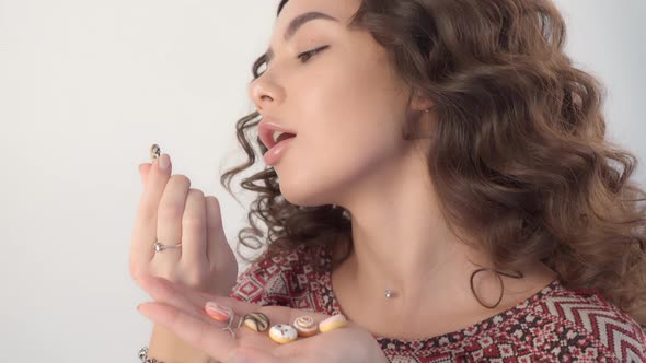 The girl holds sweet donuts in her hands, regretting that she can't eat them