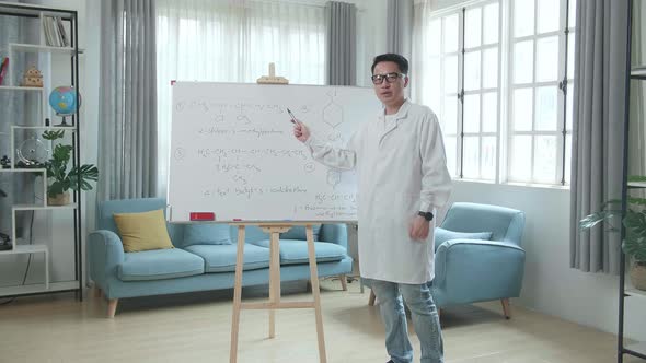 Asian Male Teacher With Glasses Teaching Chemist At Home