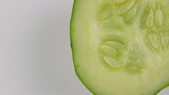 Round Slice of Cucumber Rotating on White Background