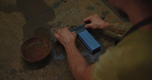 Medieval Craftsman is Sharpening Forged Steel Knife By Japanese Waterstone Closeup View  Prores