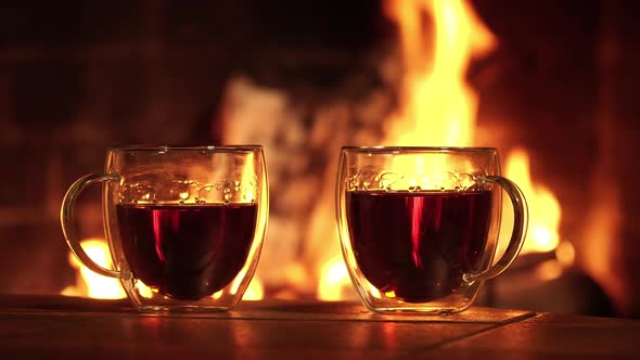 Glass Cups with Tea on the Background of the Fireplace