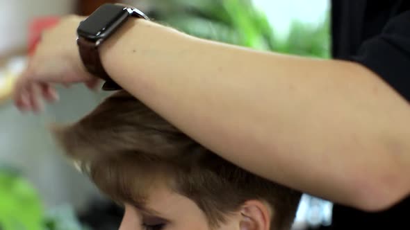 Close-up of Hands Doing a Hairstyle. Closeup of Professional Hairdresser Hands Doing Beautiful