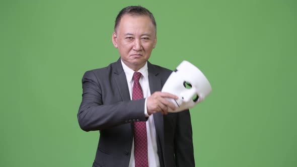 Mature Japanese Businessman with White Mask As Concept