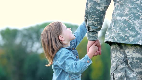 Girl Looking Up and Pointing, Holding Hand of Father