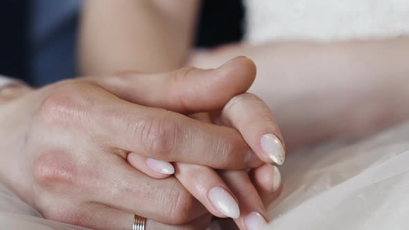 Newlywed Wife and Husband Join Hands Sitting Together