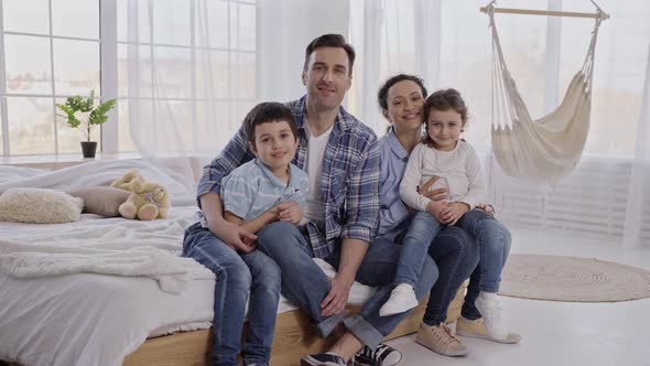 Friendly Family with Kids Posing on Camera Indoors