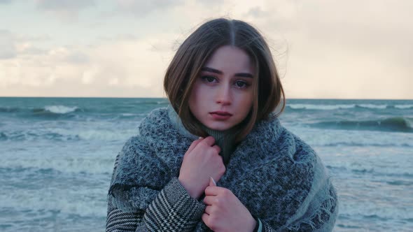 Lonely Beautiful Girl on Seashore Looks to Camera