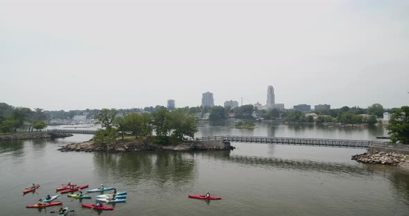 Lowering Aerial View From Small City to Kayakers on a Lake